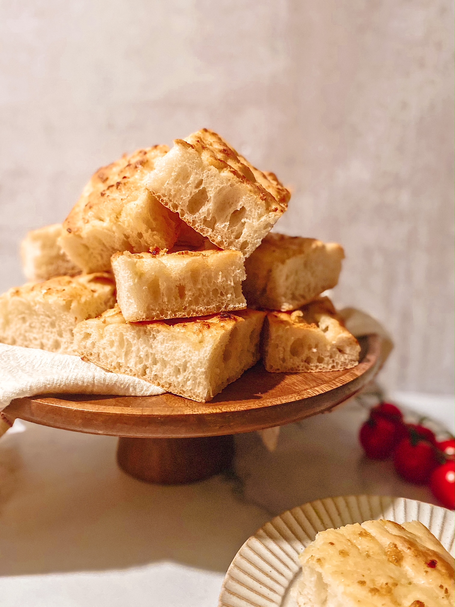 A wooden plate of garlic topped Lebanese talami bread.